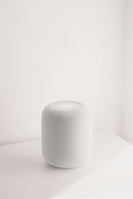 A white smart speaker on a white surface.